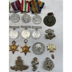 Two George VI Africa Stars, two 1939-1945 Stars, Italy Star, Atlantic Star, various WWII War and Defence medals, cap badges etc 