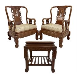 Pair Chinese hardwood armchairs, the backs with mother of pearl inlays depicting naturalistic scenes, decorated with carved and pierced scroll work, the supports carved with dragons and scrolled terminals (W69cm, H101cm, D69cm), together with matching lamp or side table, inlaid with floral decoration (57cm x 52cm, H59cm)