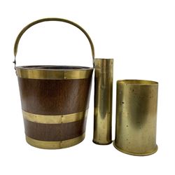 Early 20th century oak and brass coopered bucket with swing handle and removable copper liner, together with two brass shell cases (3)