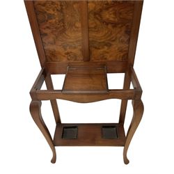 Early 20th century walnut hallstand, raised back with rectangular bevelled plate over double figured panels, surrounded by coat hooks, fitted with single hinged glove box, the undertier with twin inset umbrella drip trays, united by cabriole supports