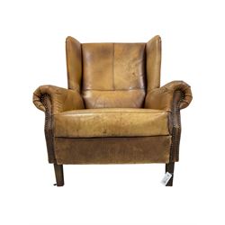 Georgian design wingback armchair, upholstered in brown tan leather with studwork, raised on square tapering supports