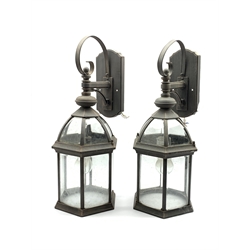 Pair of patinated metal porch lanterns of hexagonal form with bevelled glass panels, H57cm 