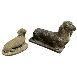 Two weathered cast stone statues of Dachshunds on bases, largest W60cm
