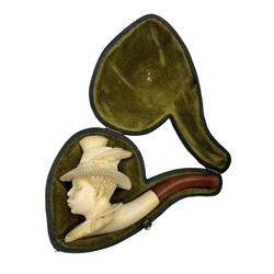 Cased Meerschaum pipe, carved in the form of a young man wearing a feather trimmed straw hat, in fitted leather case 