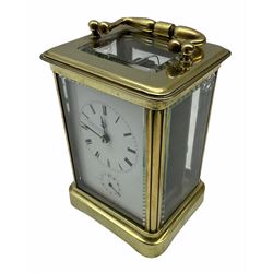 A late 19th century French Corniche cased carriage clock with alarm sounding on a bell, eight-day timepiece movement with a platform cylinder escapement, white enamel dial with roman numerals, minute track and steel hands, subsidiary alarm dial with counter-clockwise Arabic numerals. half-hour markers and setting hand, bevelled glass panels to the case and a rectangular glass panel to the top of the case. 