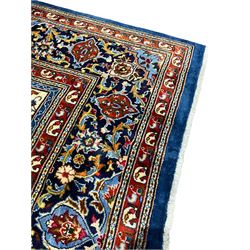 Persian Bakhtiari indigo ground garden rug, the field decorated with four rows of panels each depicting contrasting scenes of urns, trees of life, decorative pillars, Boteh motifs and birds of paradise, the palmette decorated indigo border guarded by crimson bands with repeating Boteh motifs