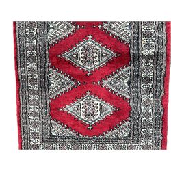 Small red ground rug, decorated with three lozenges (103cm x 62cm); and a small red ground rug with overall floral design (138cm x 69cm)