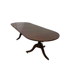 Regency design mahogany twin pedestal dining table, the oval top with reeded edge raised on turned vasiform pedestal terminating in a tripod base, the splayed cabriole supports with brass hairy paw feet and castors, with additional leaf