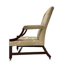 George III mahogany Gainsborough armchair, wide seat and back upholstered in pale green damask fabric, the curved arm supports with turned roundels to terminals, raked back with out splayed supports and square front supports joined by plain stretcher rails, on brass castors