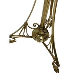 Art Nouveau brass floor standing oil lamp in the manner of W.A.S Benson, circa 1900, with opaque moulded glass shade, brass reservoir and adjustable knopped column  raised upon an swept openwork triform base with stylized feet, H186cm 
