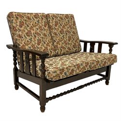 Early to mid-20th century oak framed two seat reclining sofa, slatted back and seat, spiral turned arm supports, raised on square legs with barley twist front stretcher, the loose cushions upholstered in floral patterned fabric