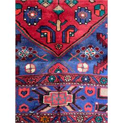 Persian Hamadan red ground rug, the field decorated with stylised flowerhead and bird motifs, the guarded border decorated with repeating geometric design