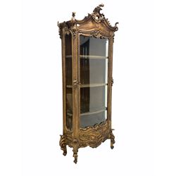 19th century French giltwood and gesso vitrine display cabinet in the rococo taste, the top surmounted by scrolling applied acanthus leaf decoration over full length glazed bow front door enclosing velvet lined interior with three shelves, raised on conforming scrolled acanthus leaf front supports W85cm, H207cm, D32cm