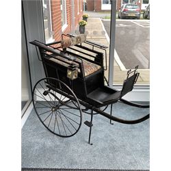 Late 19th century ebonised hand drawn child's carriage, stencilled gilt monogram 'HWB' over 'Perseverando' with two original carriage lamps, raised on leaf suspension and spoke wheels with rubber treads, the central hub inscribed 'W. Brooke Builder Manchester' having been completely restored in the 20th century L164cm