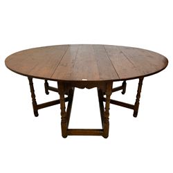 18th century design country oak dining table, the oval drop-leaf top over a shaped apron, raised on turned supports with twin gate-leg action united by stretchers
