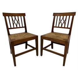 Pair of 19th century country elm chairs, plain rectangular cresting tail over pierced back, drop in rush seats, on square tapering supports joined by plain stretchers