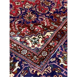  Large Persian fine Tabriz red ground carpet, central medallion on busy red field, with stylised foliate to multi line border, 406cm x 304cm
