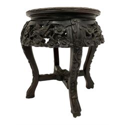 Late 19th to early 20th century Chinese hardwood vase stand, circular top with floral carved edge and central marble inset, the frieze pierced and carved with flower heads and birds, raised on cabriole supports united by X-stretcher