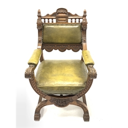 Early 20th century walnut carved throne chair, with shell pediment and shaoed cresting rail over turned spindles, floral carved and scrolled open arms, leather upholstered seat back and arm rests, raised on 'X' frame, W59cm