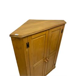 19th century pine low corner cupboard, fitted with two panelled doors opening to reveal three fixed shelves and two small drawers, raised on turned bun feet