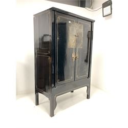 Chinese black lacquer marriage cabinet, the sides with geometric gilt painted decoration, two doors enclosing an interior fitted with two shelves and one long drawer, raised on square section supports W115cm, H184cm, D63cm