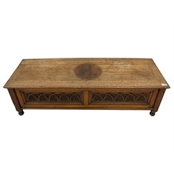 Early 20th century oak ‘bay window’ shaped blanket chest or coffer, hinged top, the front with two lunette carved panels flanked by fluted uprights, on turned feet