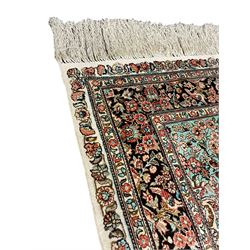 Hereke silk rug, pale pink ground field decorated with floral urn and bird motifs, decorated profusely trailing foliate and flower head motifs, the repeating guarded border decorated with stylised flower head motifs