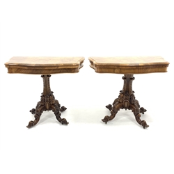  Pair Victorian well figured walnut serpentine card tables, the fold over revolving tops revealing brown crushed velvet playing surfaces, each raised on pedestal and four scroll and leaf carved splayed supports terminating in recessed brass castors, stamped 'Loach & Clarke's Patent' W94cm, H75cm, D48cm  