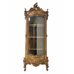 19th century French giltwood and gesso vitrine display cabinet in the rococo taste, the top surmounted by scrolling applied acanthus leaf decoration over full length glazed bow front door enclosing velvet lined interior with three shelves, raised on conforming scrolled acanthus leaf front supports W85cm, H207cm, D32cm