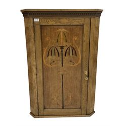 Art Nouveau period oak corner cupboard, the dental cornice over one inlayed door, opening to reveal three fixed shelves  