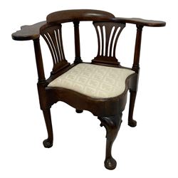 George III carved mahogany elbow chair, curved cresting rail terminating to swept arm rests, supported by columns and pierced splats, the drop-in seat upholstered in contemporary patterned ivory fabric, shaped apron on scroll topped cabriole front support with pad feet