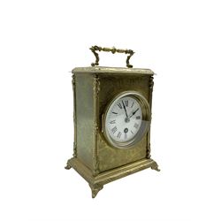 A French 19th century table clock in a decoratively engraved brass case on splayed bracket feet with carrying handle, white enamel dial, Roman numerals, minute markers, non-matching steel hands, dial attached to an eight-day spring driven movement. With key and pendulum.



