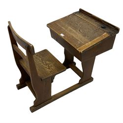 Early 20th century oak school desk with integral chair, the hinged writing slope with ink well and pencil groove, on shaped supports 