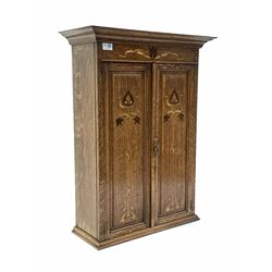 Early 20th century Art Nouveau oak wall hanging cupboard, projecting cornice over frieze and two fielded panelled doors with stylised floral inlay, enclosing two shelves W57cm, H76cm, D24cm