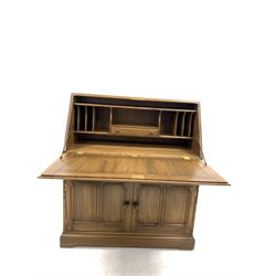 Ercol 'golden dawn' stained elm bureau, the three panelled fall front enclosing correspondence shelves and drawer, over two panelled cupboard doors enclosing shelf, raised on a shaped plinth base W94cm, H109cm, D43cm