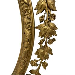 19th century gilt wood and gesso girandole wall mirror, oval frame with ribbon tied pediment intertwined with trailing foliage branch, decorated with small flower heads, the inner frame decorated with foliate and thistle mouldings, two branch candelabra surrounded by lower ribbon tie