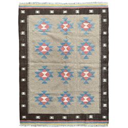 Kilim rug, light brown ground field decorated with geometric star motifs, dark brown border band and multi-coloured end bands