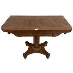 Regency plum pudding mahogany card table, fold over revolving top revealing baize lined playing surface, frieze with moulded beaded edge with flanking roundel design, column with lobe carved collar, quadruform base with applied rose detail to the turned feet