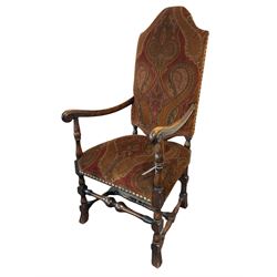 Charles II style high back upholstered carver armchair, upholstered in Paisley type patterned fabric decorated with scrolled Boteh motifs, open arms on turned supports joined by stretchers