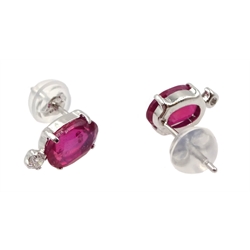  Pair of platinum oval ruby stud earrings, each set with a diamond, stamped Pt 900, ruby total weight 2.00 carat   