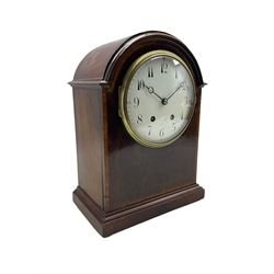 French -  Edwardian mahogany 8-day mantle clock, with a break arch top, inlaid satinwood stringing and banding, case on a moulded plinth raised on four bun feet, with a French eight-day movement striking the hours and half hours on a coiled gong, square movement plates stamped “B.T.G Medaille d'Or”, six-inch enamel dial with upright Arabic numerals and minute markers, quarter hours in red Arabic's, with steel moon hands, cast brass dial bezel with a convex glass, brass case door with pierced sound fret. With pendulum and key.
