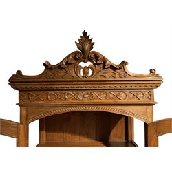 20th century oak display cabinet, shaped and pierced pediment carved with scrolled foliage, two glazed doors over two drawers and under tier, on ball and claw carved cabriole supports 