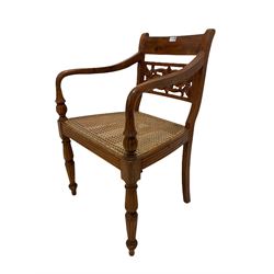 Hardwood elbow chair, carved rail back, open arms, cane seat panel, raised on reeded turned supports W57cm