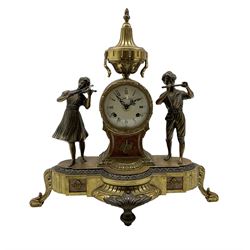 20th century - continental 8-day mantle clock, drum cased movement surmounted with a conical urn and flanked by two cast figures of young musicians, enamel dial with Roman numerals and gilt hands, twin train spring driven movement with a floating balance escapement, striking the hours and half hours (ting tang) on two bells. With key. 
