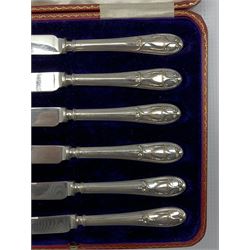 Set of twelve silver rat tail pattern coffee spoons and tongs London 1928 Maker Josiah Williams & Co, cased and a set of six silver handled dessert knives with classical urn decoration, cased.