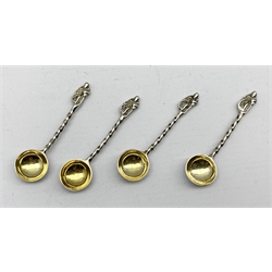 Set of four Victorian silver circular salts with embossed decoration, gilded interiors and shaped supports  with four original spoons with gilded bowls and figure finials London 1870 Maker Richards and Brown 5oz