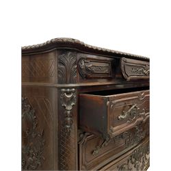 Early 20th century French design commode or chest, serpentine form with gardroon and foliate carved top, fitted with small frieze drawer over three long graduating drawers, the fronts carved with extending scrolled leafy stems, the sides decorated with foliate cartouche shields on cross-hatch ground, canted upright corners carved with acanthus leaves 