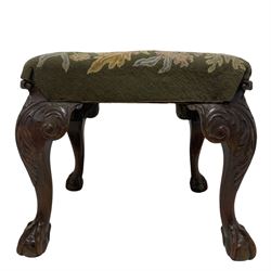 19th century George II style walnut stool, the top upholstered in floral needlework cover, scrolled acanthus leaf and bellflower carved cabriole supports with projecting scroll carved terminal, ball and claw carved feet