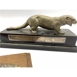Silver plated model of an otter on wooden base with presentation inscription dated 1953 L27cm, a cold painted spelter model of a fox with a pheasant on oak wall panel L23cm and a painted spelter table lighter with a gun dog and pheasant