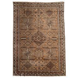 Persian Bakhtiari brown ground rug, the field decorated with clusters of floral motifs, lattice panels with flowerheads, and tree of life motifs, lozenge-shaped medallion, repeating geometric border enclosed by guard bands decorated with S-scrolls